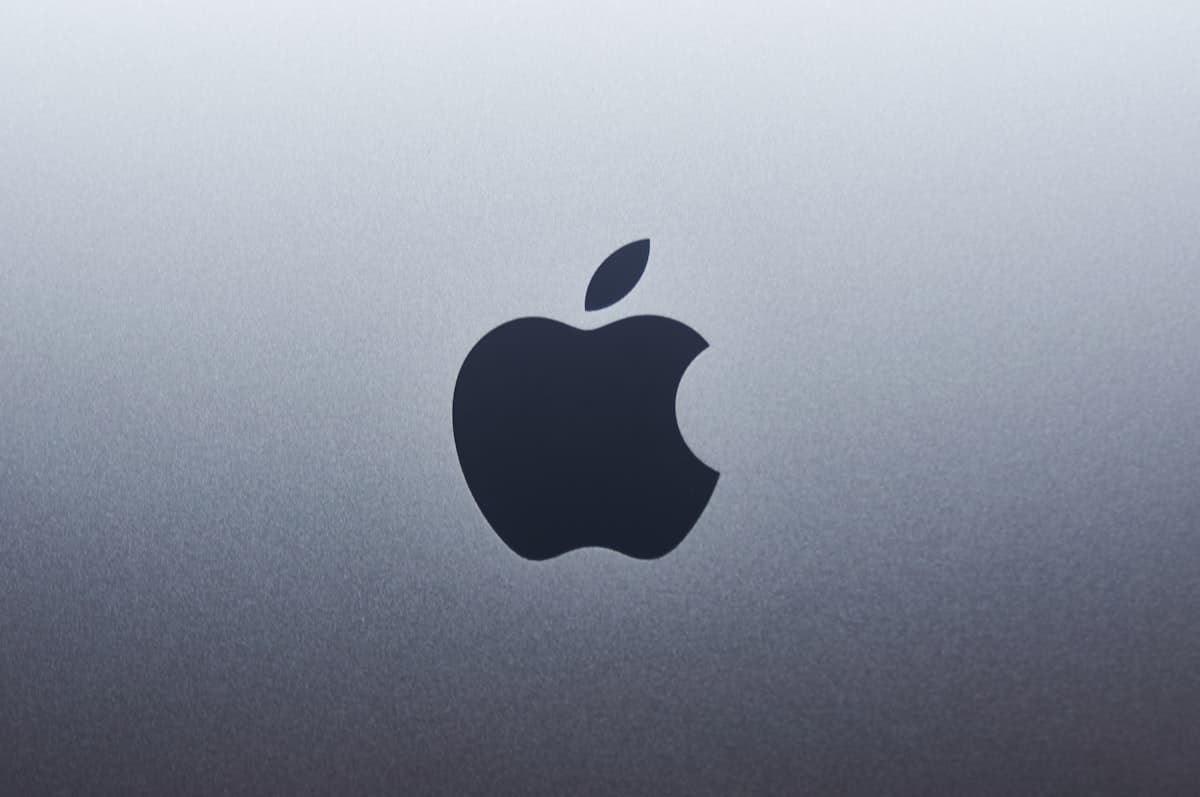 Apple logo illuminated in a minimalist setting representing the company's artificial intelligence strategy