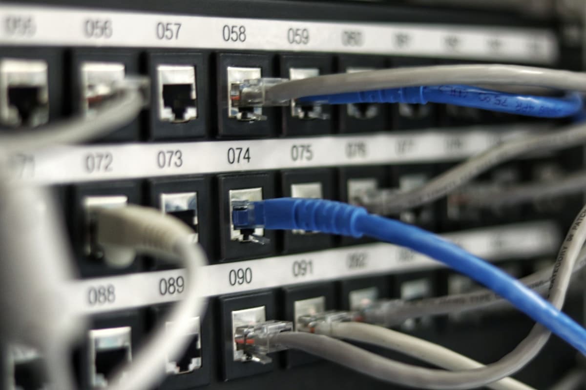 Data center with illuminated blue fiber optic cables representing network connections and communication protocols