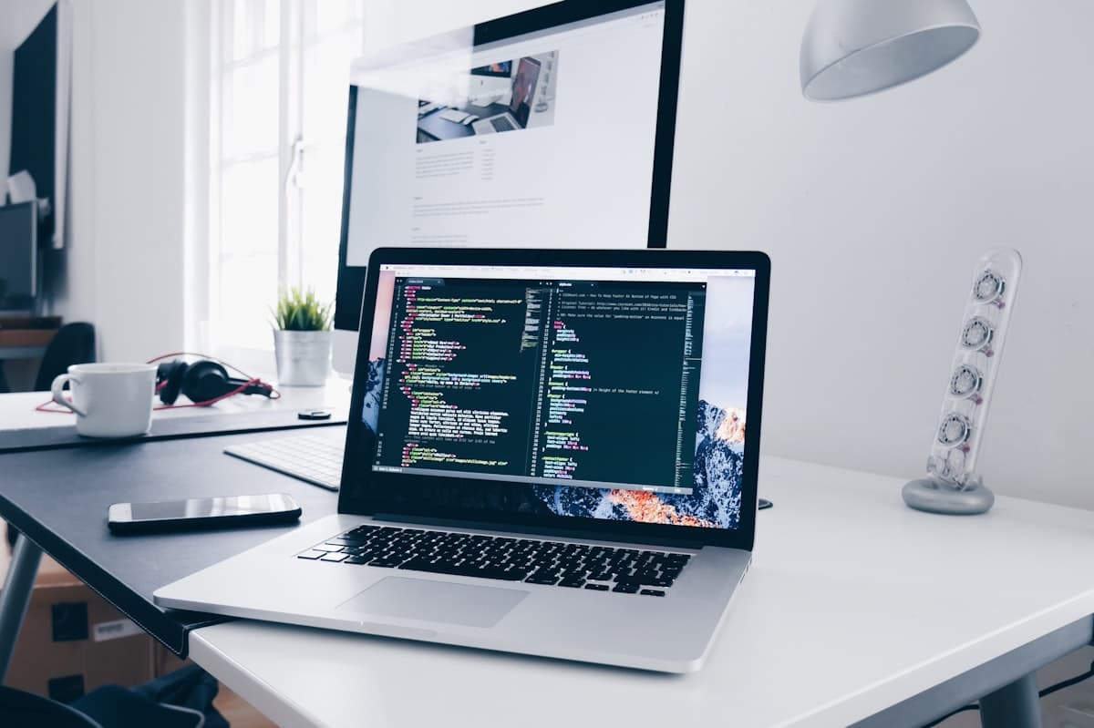 MacBook laptop mostrando código en un espacio de trabajo de desarrollador